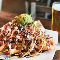 Loaded Nachos · Choice of Beer-braised pulled pork, Grilled Chicken, or Plant-based Protein, nacho cheese, t...