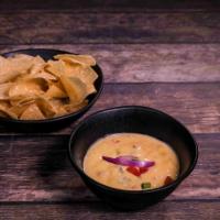 Chile con Queso · A traditional cheese goodness with tomato, jalapenos, onions and cilantro.