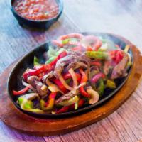 15. Fajitas · Choice of chicken or beef sauteed with garlic, onion, and peppers. Served with lettuce, pico...