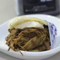 Arepa con carne mechada y queso · Arepa with shredded beef and cheese