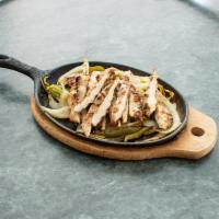 Fajita · Placed on a bed of grilled onions and bell peppers on a skillet, served with shredded lettuc...
