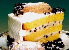 Cannoli Cake · Layers of vanilla cake filled with a family with whip cream icing, mini chocolate chips, and...