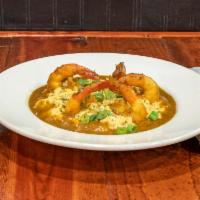 Curry Shrimp and Grits · 5 jumbo shrimp over a bed of grits in curry sauce.