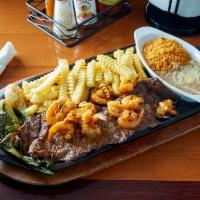 Carne Asada con Camarones Plancha · Char-broiled steak with griddled shrimp served with rice, beans, fries, grilled onions, and ...