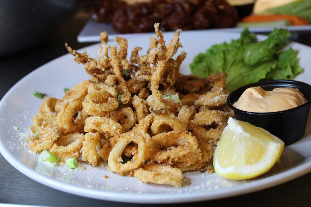 Fried Calamari  · Buttermilk battered tentacles and tubes, topped with green onions, parmesan cheese and served with a chipotle aoili.