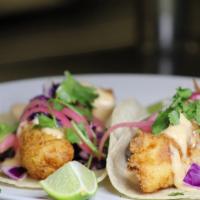Tropical Fish Tacos · Cod, lightly fried, Sriracha aioli, avocado, cilantro, lime, cabbage slaw and house pickled ...