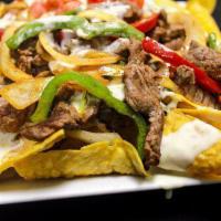 Fajita Nachos · Made with Fresh homemade corn tortilla chips, cheese, refried beans, and your choice of Stea...