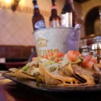 Nachos · Homemade corn tortilla chips topped with beans, carne asada and melted cheese.