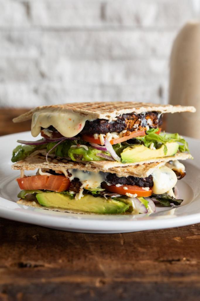Chipotle Black Bean Burger Panini · Chipotle black bean burger, chipotle ranch, pepper jack, avocado, field greens, red onion and tomatoes on a honey wheat tortilla.