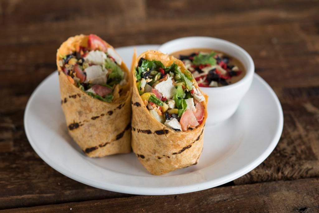 Fiesta Chicken Wrap · Sun-dried tomato wrap, crisp romaine, tomatoes, shredded carrots, cheddar, black bean and corn salsa, tortilla strips, grilled chicken and chipotle ranch dressing.