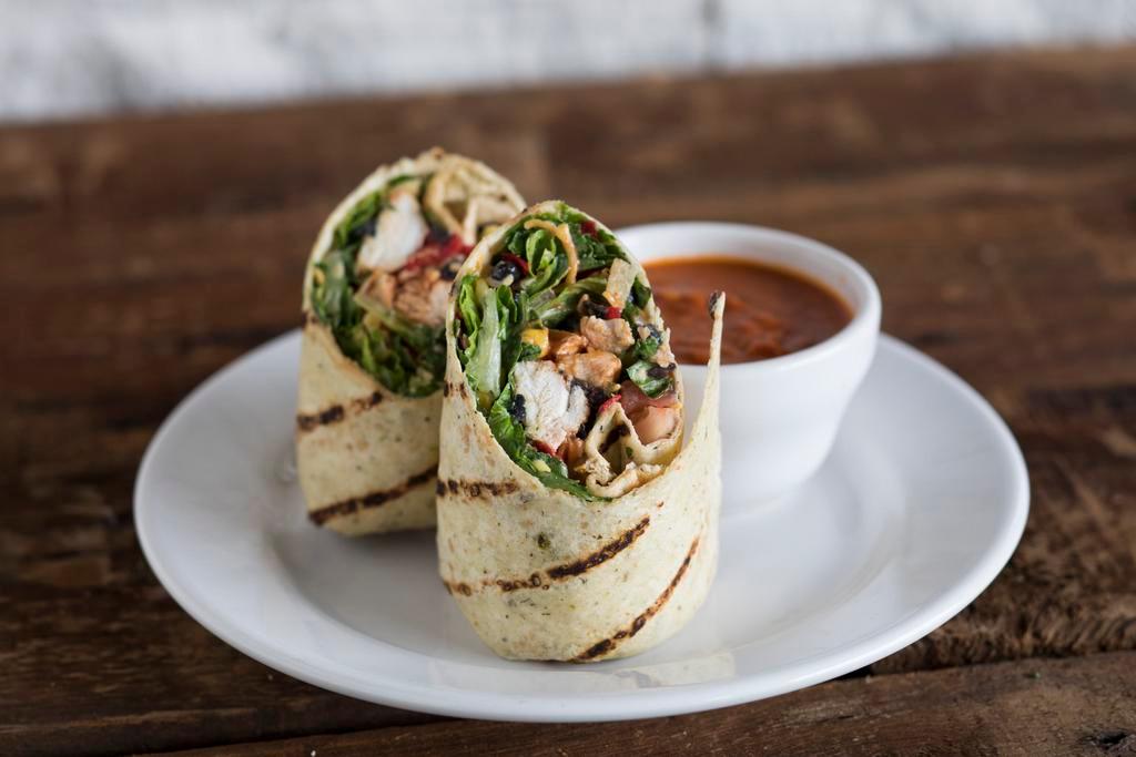 Ranchero Chicken Wrap · Herb and garlic wrap, crisp romaine, tomatoes, cheddar, sweet corn, black beans, tortilla strips, grilled BBQ chicken and ranch dressing.