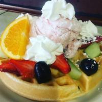 Ice cream waffle  · Waffle topped with two scoops of ice cream, fruits , and whipped cream and powder sugar.