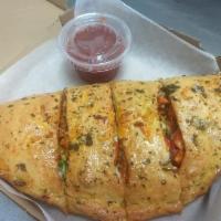 Pepperoni Calzone · Pepperoni chunks wrapped in a golden crust with cheese and homemade tomato sauce.
