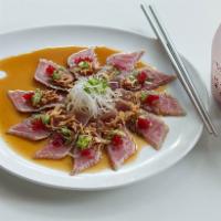 Tuna Tataki · Seared sliced tuna topped with fried garlic sauce and sesame seeds.