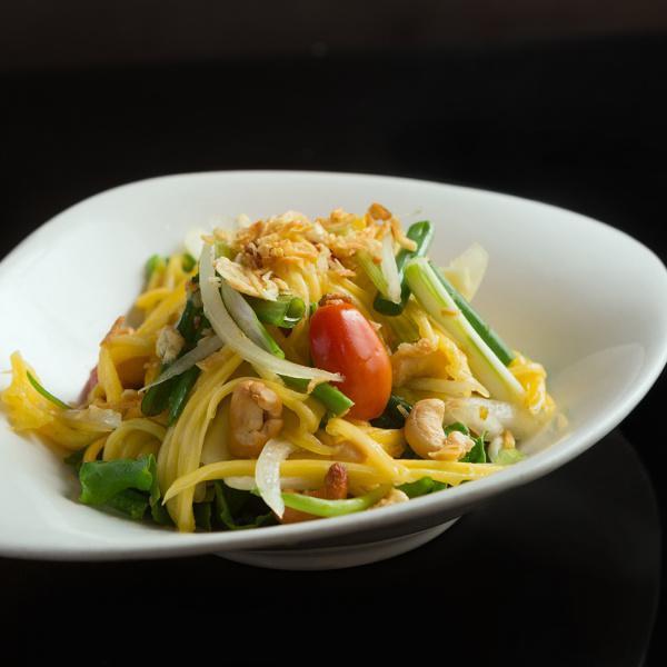 S7. Mango Salad · Shredded mango, tomatoes, cashew nut, red onion, scallion with Noodies’s lime juice dressing topped with red fried onions. Gluten-free.