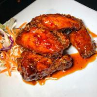 Asian Chicken Wings · Plump chicken wings deep fried and tossed in a spicy teriyaki glaze.
