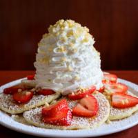Fresh Strawberry Whipped Cream Pancakes · Five fluffy buttermilk pancakes topped fresh strawberries with whip cream and macadamia nuts.