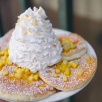 Fresh Pineapple Whipped Cream Pancakes · Five fluffy buttermilk pancakes with pineapples inside and topped with whip cream and macada...
