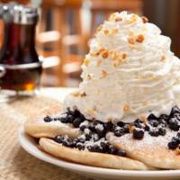Blueberry Whipped Cream Pancakes · Five fluffy buttermilk pancakes with blueberries inside and topped with whip cream and macad...