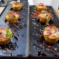 Tostones Trio · Served with blue crab and leche de tigre on top.