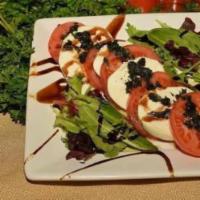 Caprese Salad · Sliced tomato, mozzarella, basil, spring mix with balsamic vinegar glaze.  Add prosciutto fo...