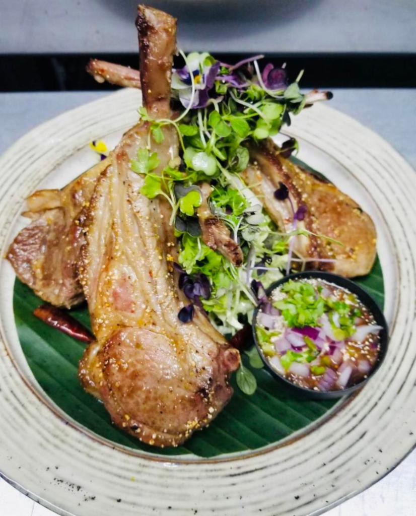 Lamb Zaab · Pan seared baby rack of isan style with cabbage and mixed microgreens. Spicy, glutenfree.