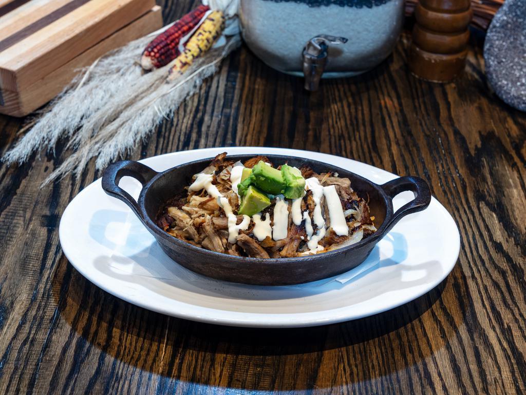 Pork Carnitas · Seared, roasted chili pork and caramelized onion served over Rio rice and borracho beans and topped with avocado and Mexican crema.