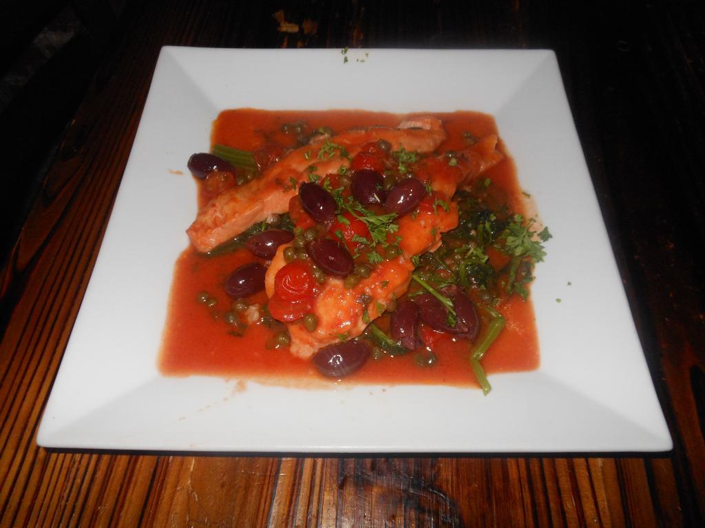 Salmone Capriccioso ·  salmon filet sauteed  with tomato sauce, black olives, and capers. Served with sauteed spinach.