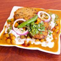 aloo Tikki Chaat · Potato paties served with chana masala(Garbanzo beans) and sauces and yoghurt onions and cil...