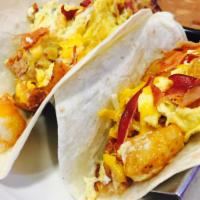Breakfast Tacos · 2 tacos on flour tortillas mixed with eggs, bacon, cheese and potatoes. Choice of side of be...