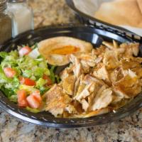 Chicken Shawarma Plate · Marinated layers of chicken thighs cooked on a vertical broiler and served with hummus, sala...