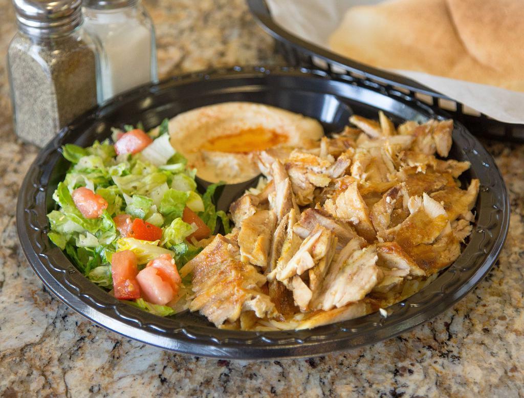 Chicken Shawarma Plate · Marinated layers of chicken thighs cooked on a vertical broiler and served with hummus, salad, rice, and pita.