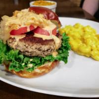 The Impossible Burger · Impossible meat on a pretzel bun with lettuce, tomato, caramelized onions, and bang bang sau...