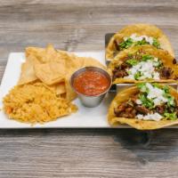Beef Tacos · 3 tacos topped with cilantro and chopped onions served with rice, chips and salsa.