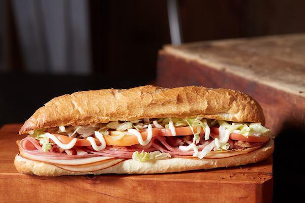 The Club Classic Sub · Ham, turkey, bacon, Wisconsin cheese blend, lettuce, tomatoes, and mayonnaise. Toasted and served with potato chips.