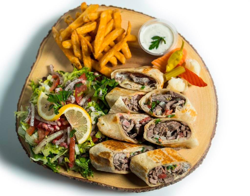 Beef shawarma · 100% halal marinated beef , onion sumac , parsley , tamtoes & tahini sauce served with your choice of salad or fries tahini sauce pickles pepperoncini