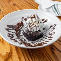 Flourless Chocolate Brownie · Topped with vanilla ice, whipped cream, and chocolate sauce (ice cream on side).