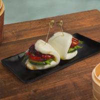 Char Siu Bao · Two steamed bao buns stuffed with slices of roasted pork, fresh scallions and fresh cucumber...