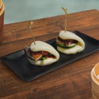 Peking Duck Bao · Two steamed bao buns stuffed with slices of roasted duck, fresh scallions and fresh cucumber...