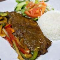 Bistec Encebollado · Grilled Steak prepared with onions, red and green peppers. Served w/rice, sweet plantains, a...