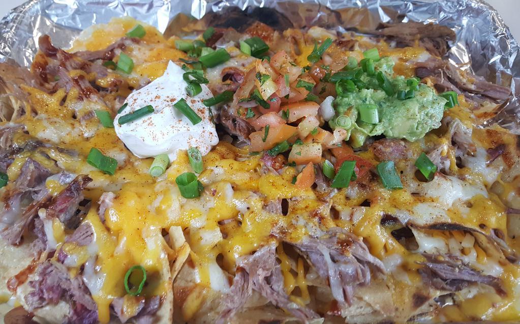 Pulled Pork Nachos · White corn chips topped with slow smoked pulled pork, BBQ sauce, a blend of cheeses, sour cream, guacamole & pico de gallo.