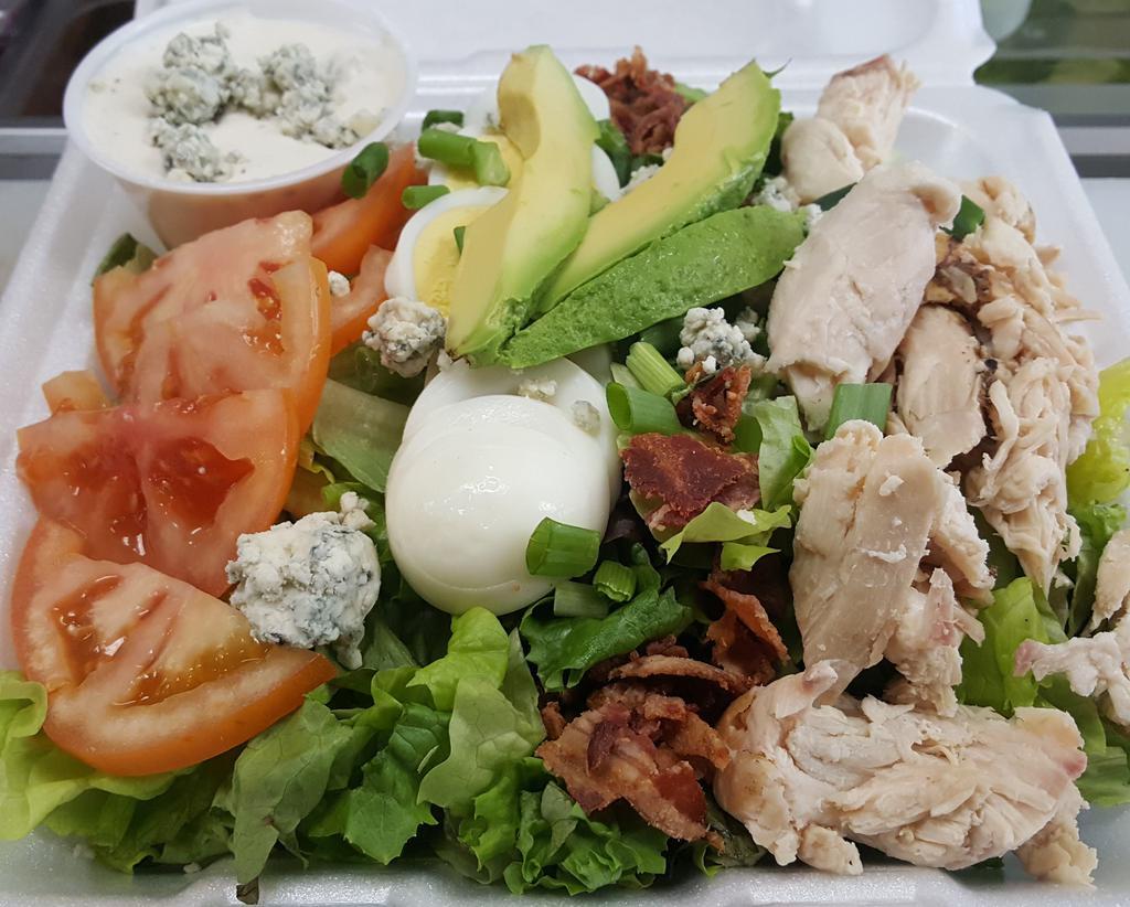 Cobb Salad · Assortment of hand washed lettuces, sliced tomatoes, hard boiled sliced egg, bacon bits, smoked chicken, blue cheese crumbles, & green onions topped with fresh slices of avocado.