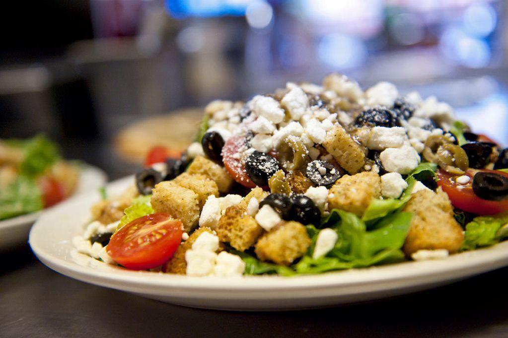 Sals Greek Style Salad · Crispy romaine lettuce, croutons, cherry tomatoes, black and green olives, feta cheese, and homemade Italian dressing with a slice of lemon. Extra dressing for an additional charge.