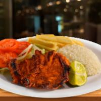 Pollo a la Plancha · Grilled chicken breast served with white rice, salad, and french fries.