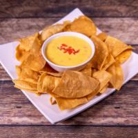 Chili con Queso · Traditional cheese dip with green chilies and chopped tomato.