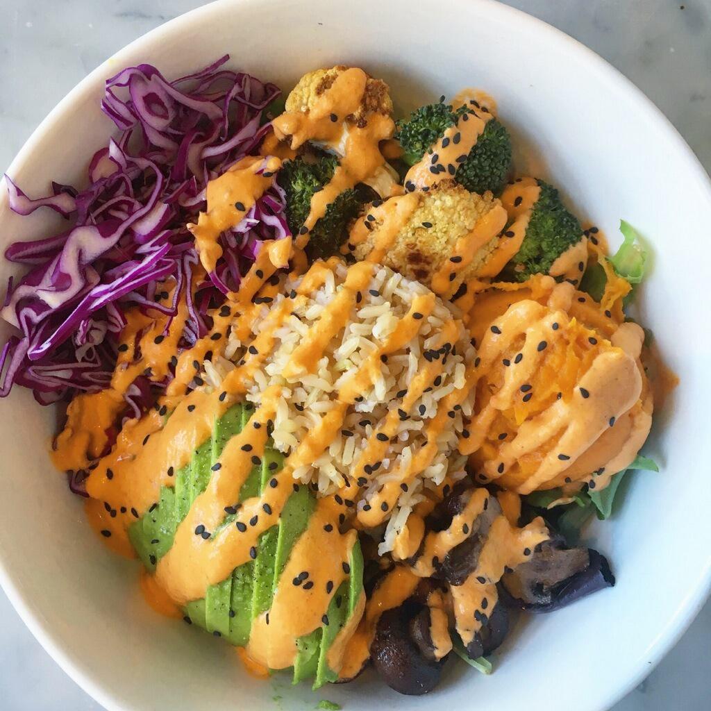 Urban Farmer Bowl / Wrap · Jasmine brown rice, mixed greens, cabbage, avocado, yams, roasted broccoli and cauliflower, roasted mushrooms, mixed greens. Red pepper almond dressing. Available as a grain bowl or in a raw spinach, gluten-free wrap.