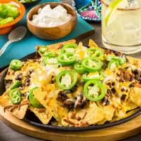 Nachos Supreme · Crisp tortilla chips loaded with spicy taco meat, Monterey Jack and cheddar cheeses, diced t...