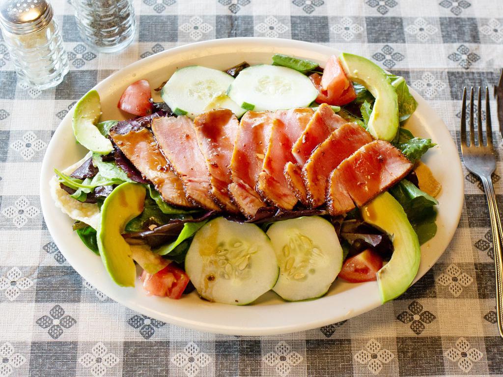 Seared Tuna Salad · Seasoned tuna, fresh slices of avocado served over crispy wontons, tomatoes, cucumbers and mixed greens. Finished with ginger dressing and a drizzle of sweet soy sauce.