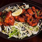 Jashan Murgh Tikka · Chicken thighs marinated overnight, roasted in a tandoor oven, served with onions, lemons, and chutneys