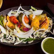 Salmon Tikka · Salmon marinated in cumin-coriander paste roasted in tandoor and served with onion, lemons, ...